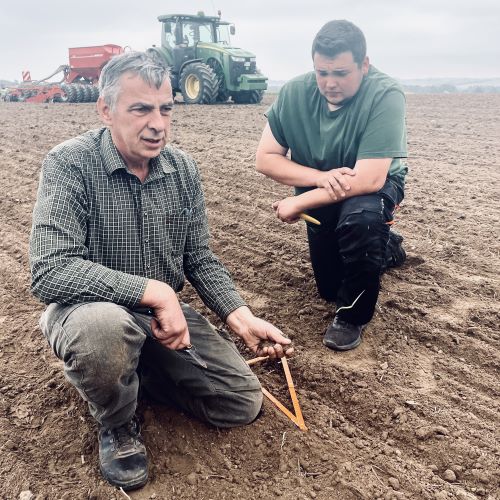 Zwei Landwirte prüfen Saatbett auf Feld