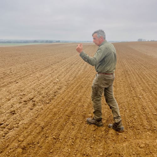 Landwirt geht über frisch bearbeitetes Feld